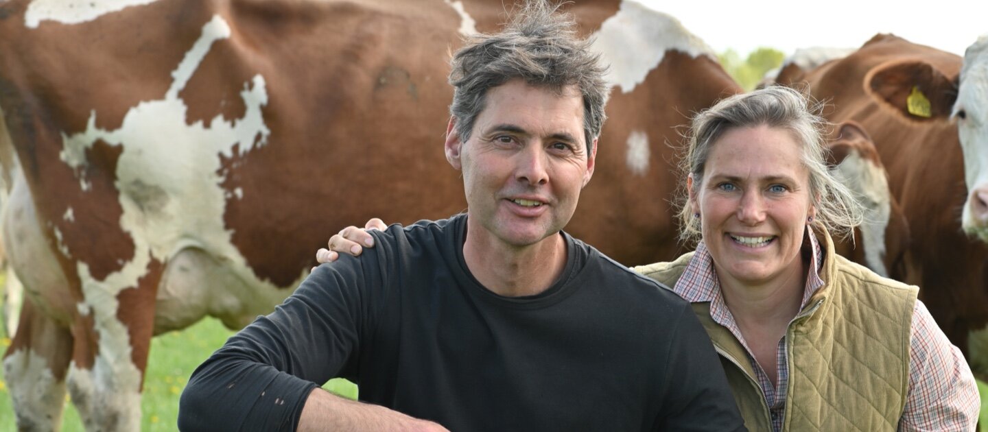 man en vrouw bij koeien op boerderij