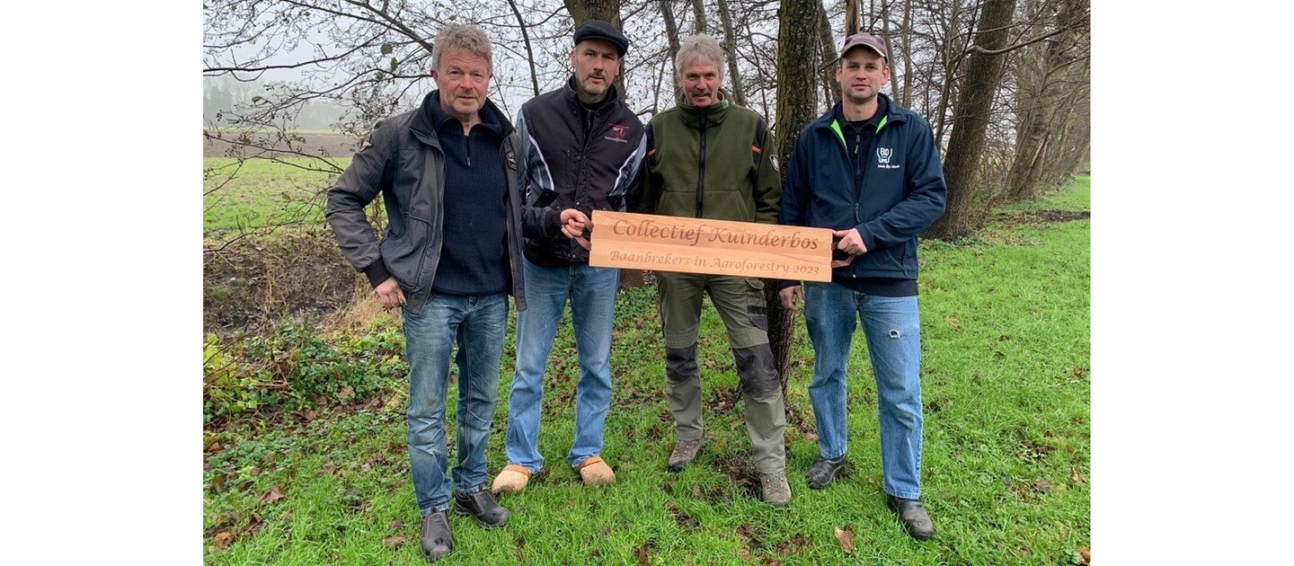 Groep mannen laten award zien in weiland