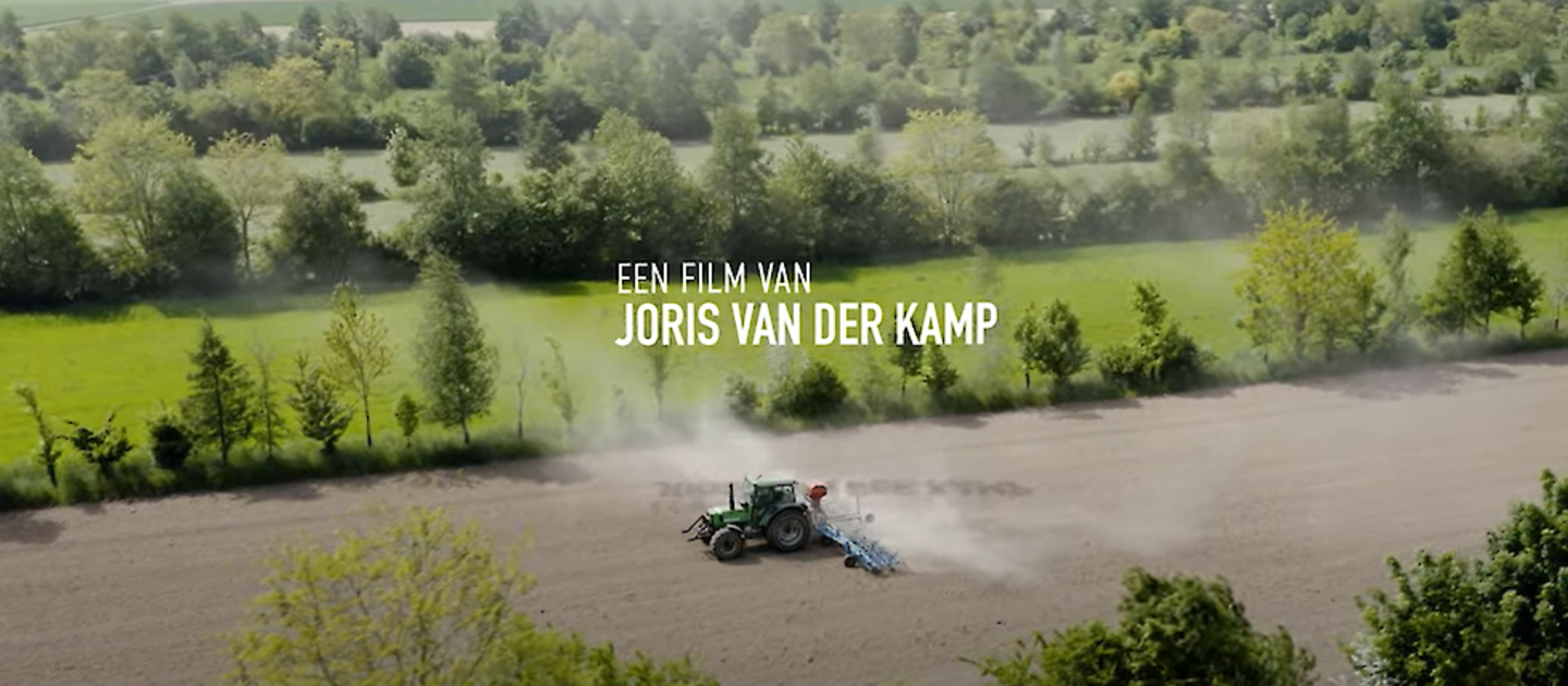 Tractor op akker met bomen