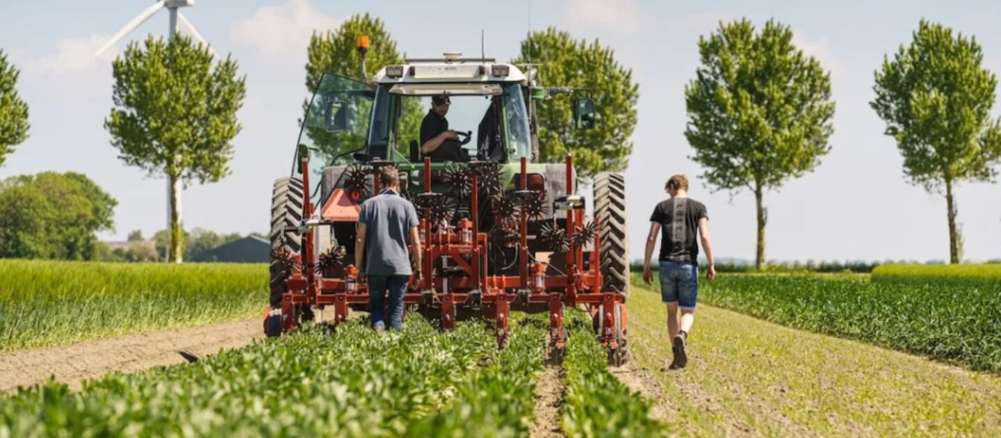 Tractor op akker met bomen